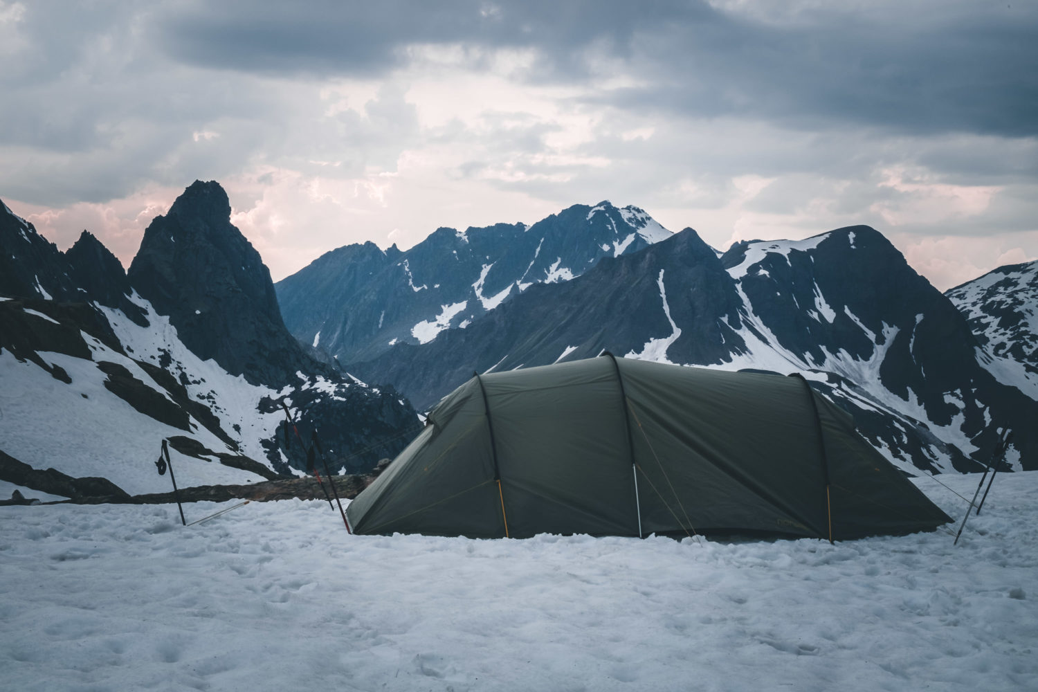 Zelt im Schnee mit Bergen im Hintergrund