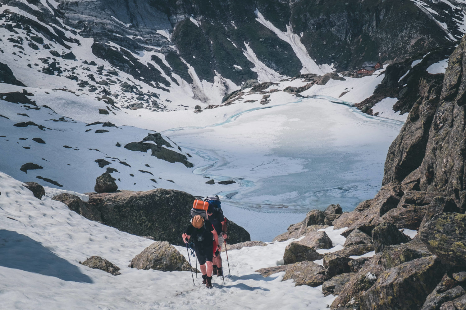 Aufstieg zum Passo di Leit mit zwei Wanderern und Bergsee im Hintergrund