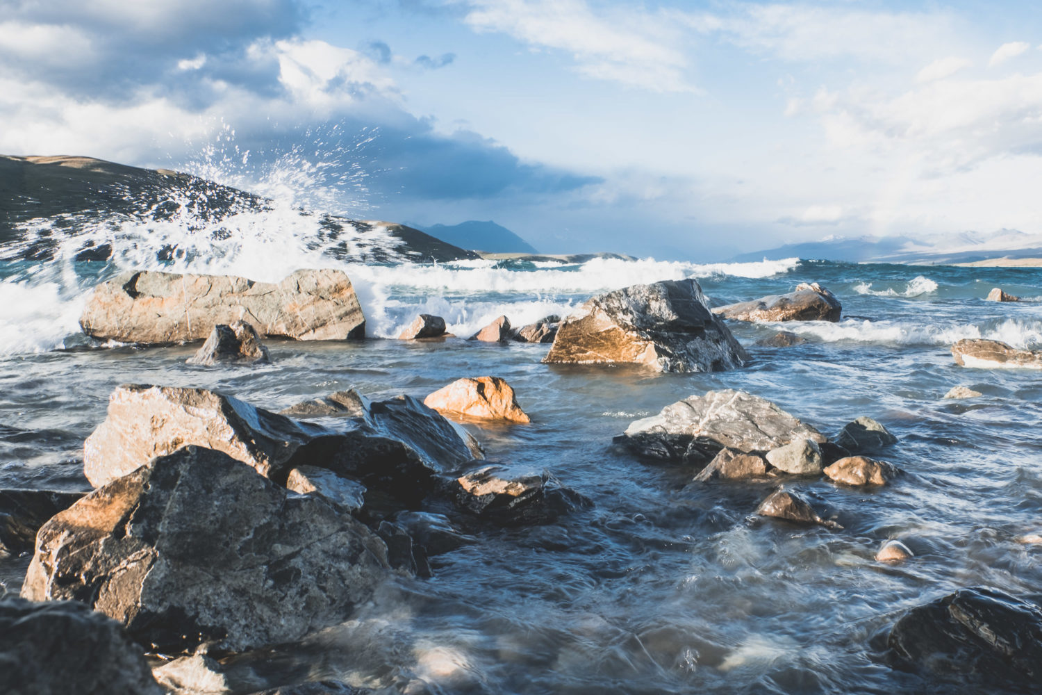 Welle spritzt gegen Steine im Wasser
