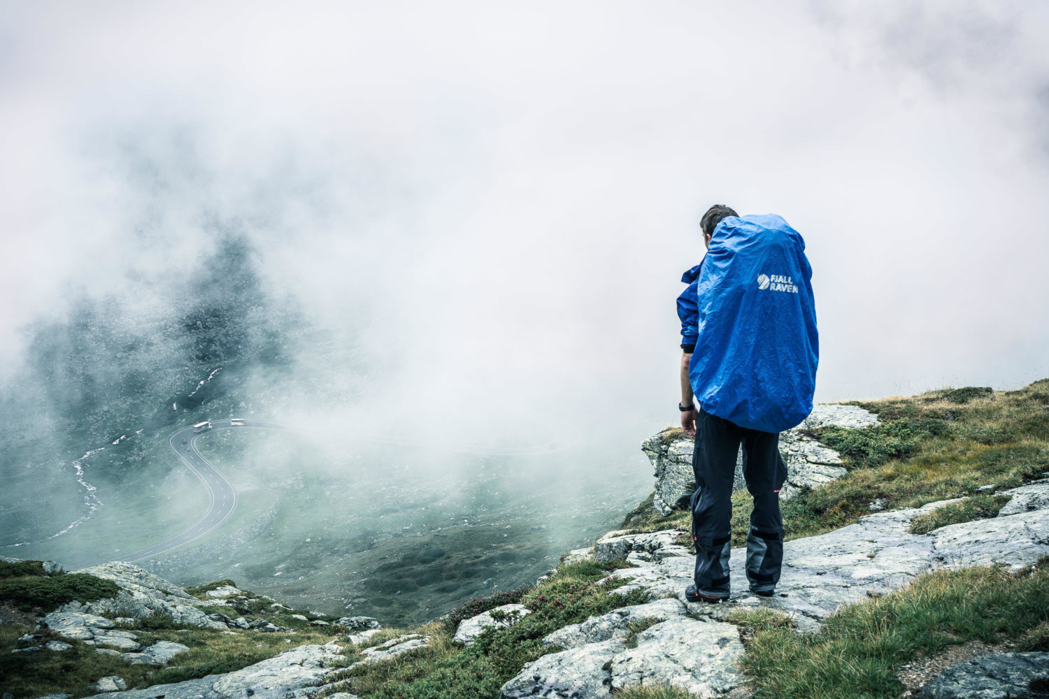 Wanderer mit Rucksack von Fjällraven vor wolkenverhangener Kuli