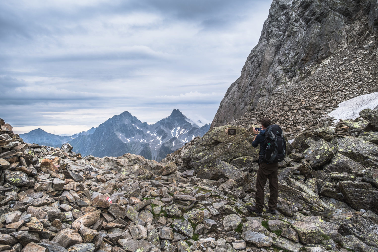 Wanderer fotografiert mit dem Handy Berge gegenüber dem Kuchenjöchli