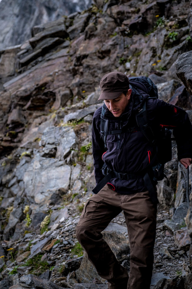 Wanderer steigt an einem Drahtseil über schroffes Gelände ab